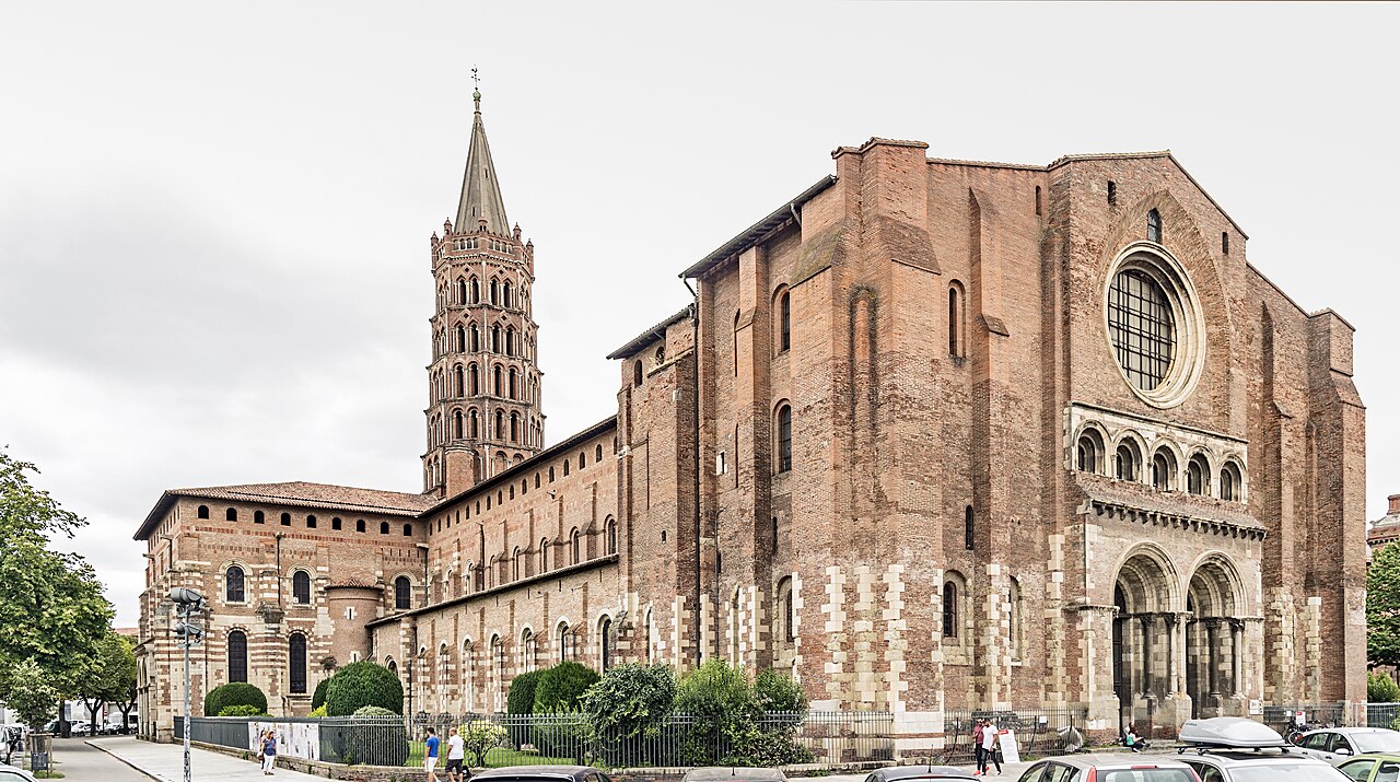 Basilique Saint-Sernin de Toulouse, clocher octogonal de brique et portail ouest, vu depuis le trottoir.